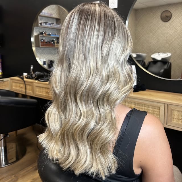 Longueurs blond platine parfaitement lisses dans le salon